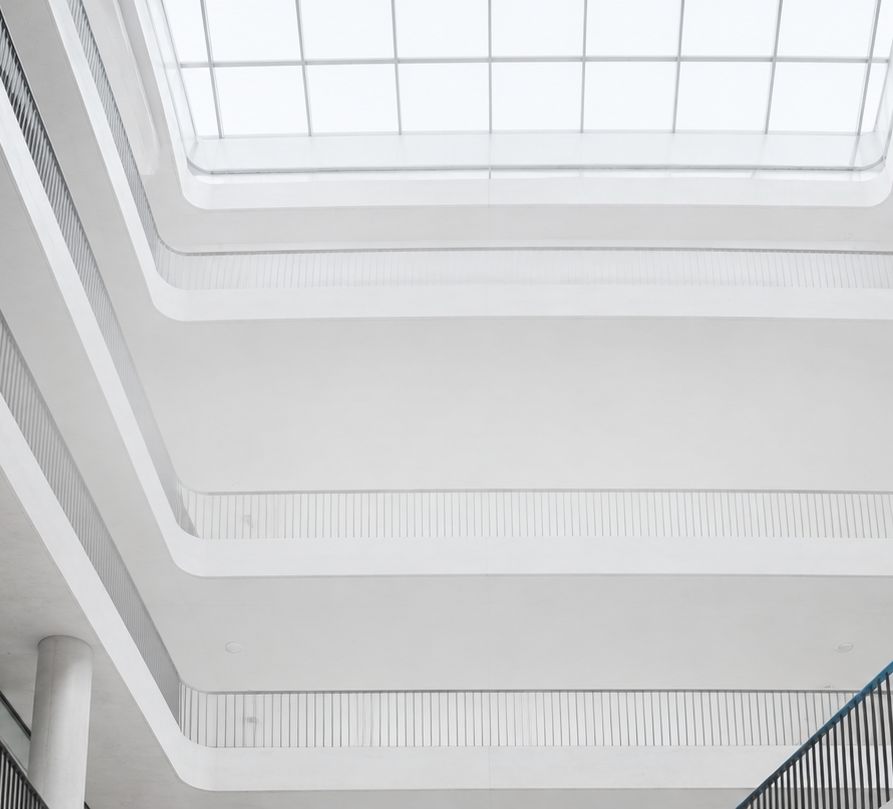 Looking up through the skylight of a concrete atrium