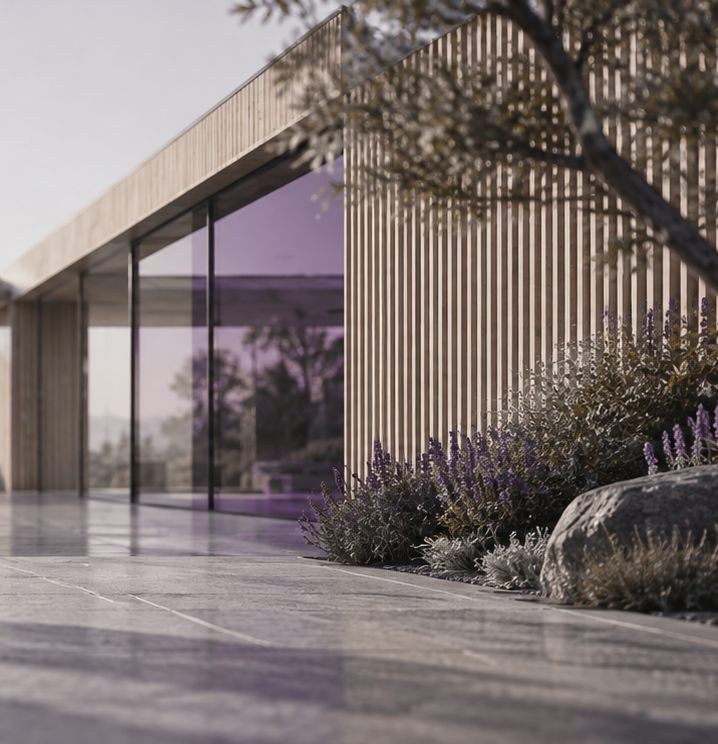 A timber and glass pavilion set into planting and stone paving